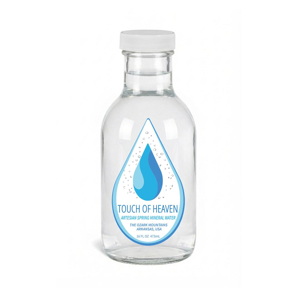 Clear glass water bottle with 'Touch of Heaven' label on a white background