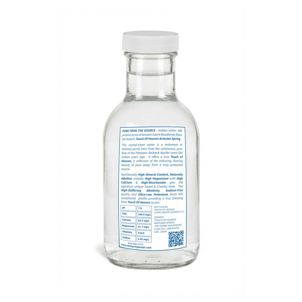 Clear glass water bottle with a label on a white background